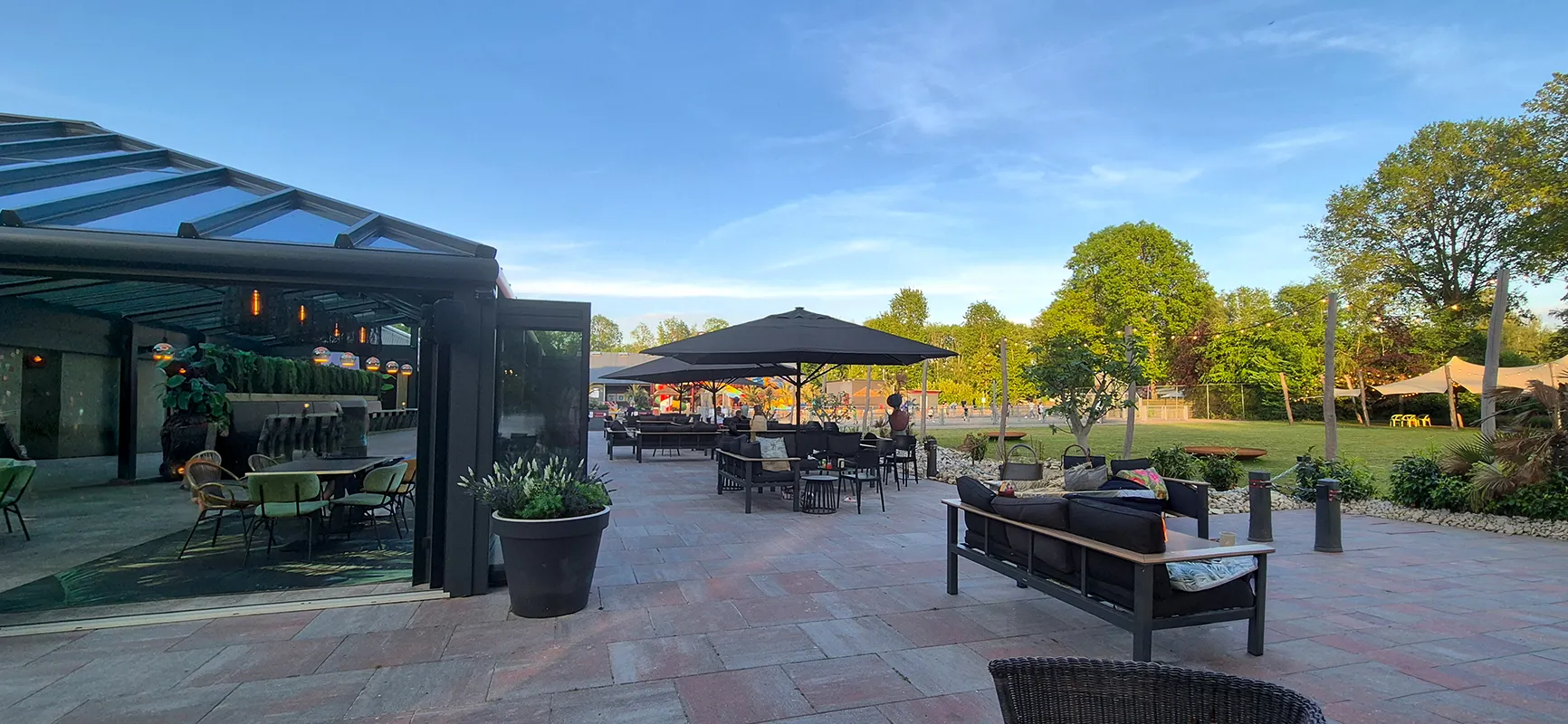 Restaurantterrasse mit Palmen und bequemen Sitzmöglichkeiten